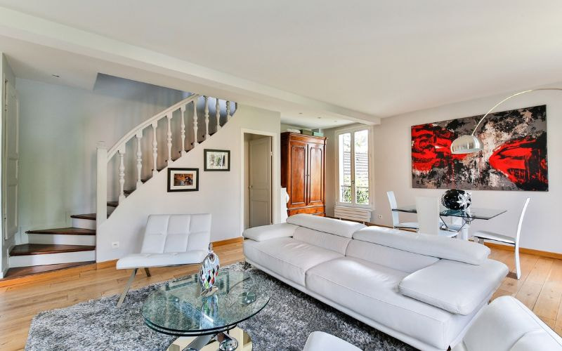 Bố trí sofa băng và ghế đơn trong phòng khách có lối đi mở